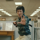 Ke Huy Quan in fighting stance... wearing khakis in the middle of what looks like a boring old office.